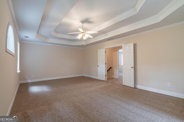 unfurnished room featuring ornamental molding, ceiling fan, carpet floors, and a raised ceiling