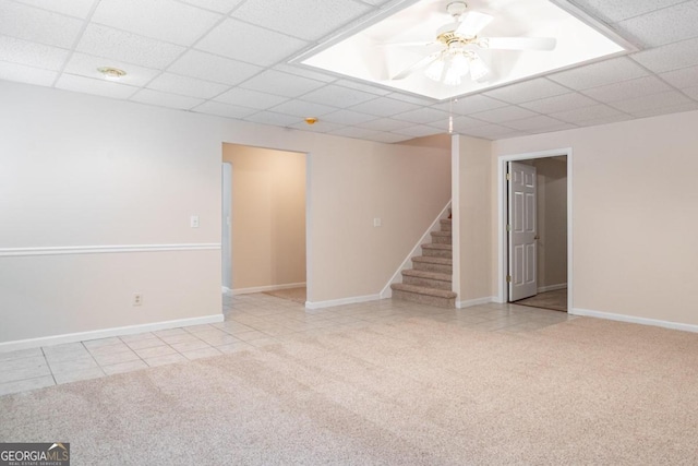 unfurnished room featuring a paneled ceiling, light tile patterned floors, and ceiling fan