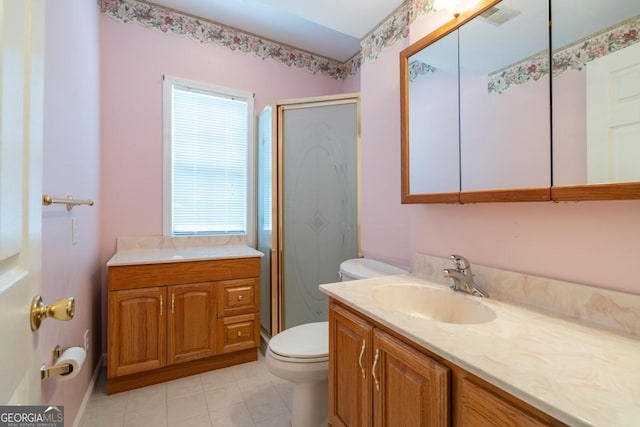 bathroom featuring vanity, toilet, walk in shower, and tile patterned flooring