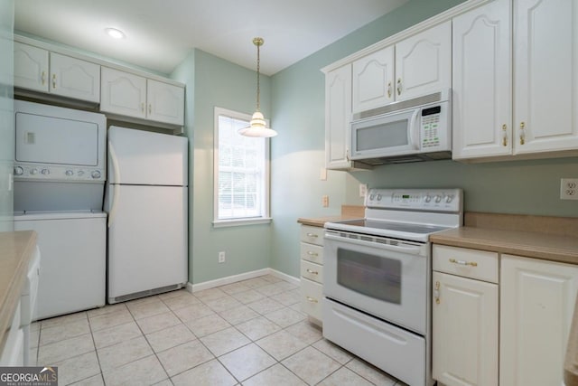 kitchen featuring stacked washer / drying machine, hanging light fixtures, light tile patterned floors, white cabinetry, and white appliances