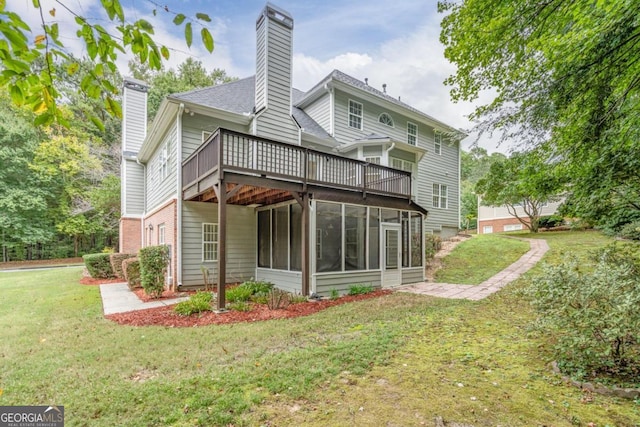 back of property with a sunroom, a deck, and a lawn