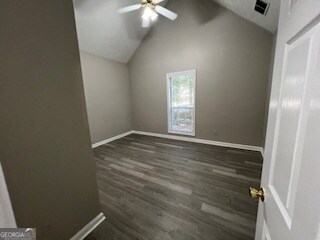 spare room featuring lofted ceiling, dark wood-type flooring, and ceiling fan