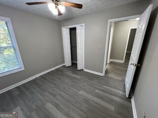 unfurnished bedroom featuring ceiling fan and dark hardwood / wood-style floors