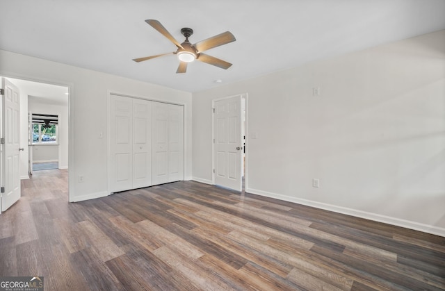 unfurnished bedroom featuring a closet, ceiling fan, and dark hardwood / wood-style flooring