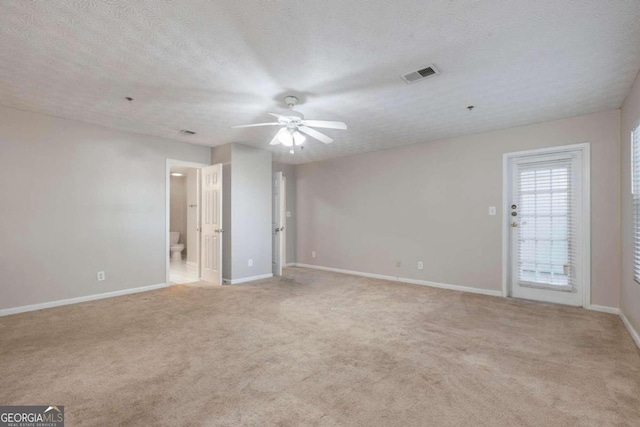 carpeted spare room with a textured ceiling and ceiling fan