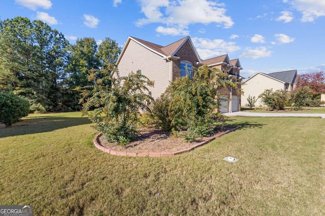 view of side of property with a yard and a garage