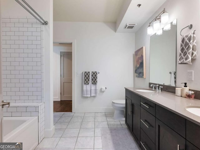 bathroom featuring vanity, a tub, toilet, and tile patterned floors