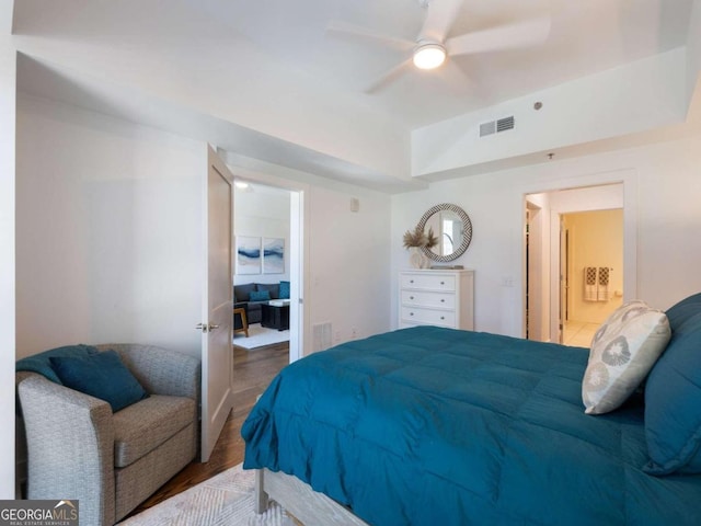 bedroom with hardwood / wood-style flooring, ensuite bath, and ceiling fan