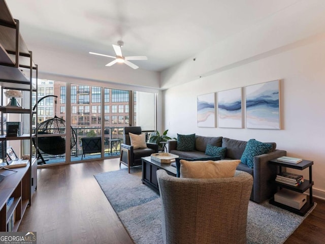 living room featuring dark wood-type flooring and ceiling fan