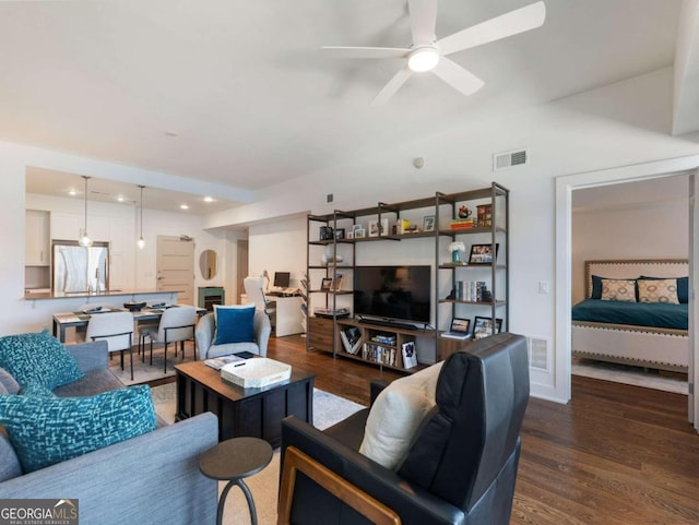 living room with dark wood-type flooring and ceiling fan