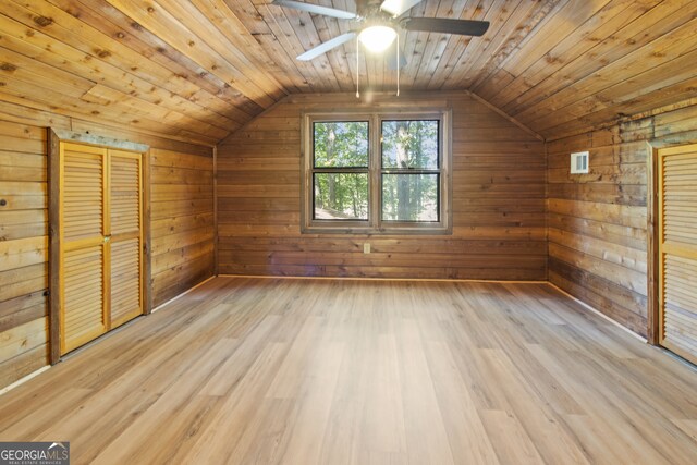 additional living space with wooden ceiling, light hardwood / wood-style flooring, and wooden walls