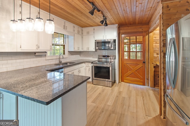 kitchen featuring sink, light wood-type flooring, kitchen peninsula, stainless steel appliances, and decorative light fixtures