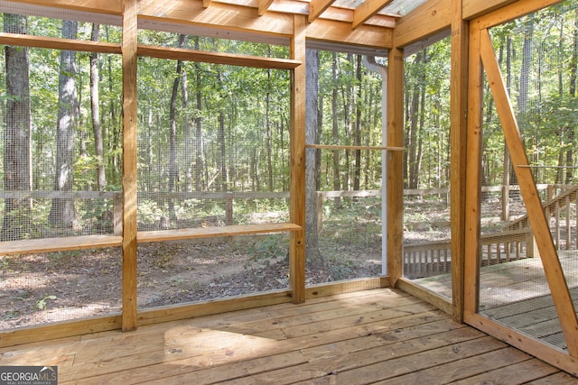 unfurnished sunroom featuring vaulted ceiling with skylight