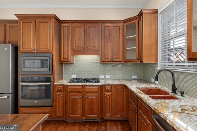 kitchen with tasteful backsplash, ornamental molding, dark hardwood / wood-style floors, sink, and stainless steel appliances