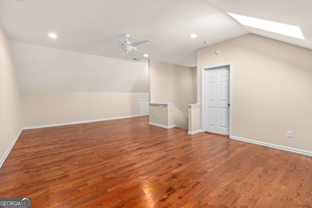 bonus room with vaulted ceiling with skylight, hardwood / wood-style flooring, and ceiling fan