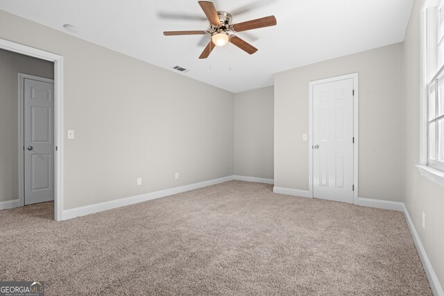 unfurnished room with carpet flooring and ceiling fan