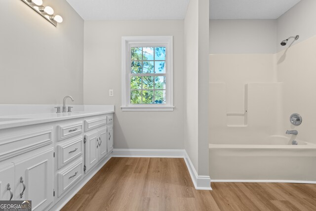 bathroom with vanity, hardwood / wood-style flooring, and  shower combination