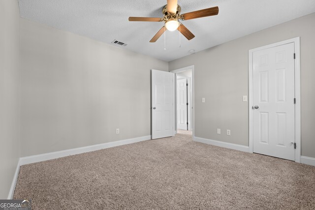 unfurnished bedroom with carpet flooring, a textured ceiling, and ceiling fan