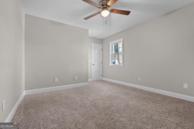 carpeted spare room featuring ceiling fan and a textured ceiling