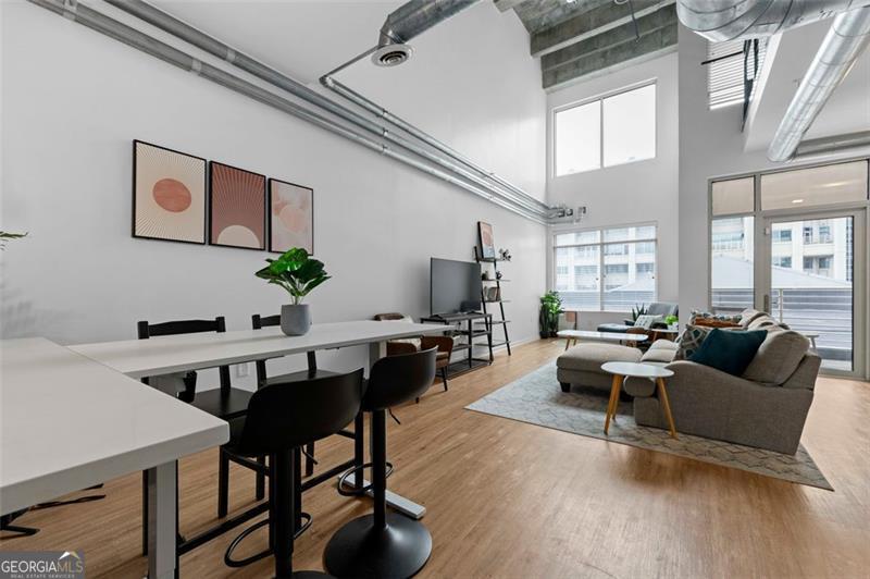 living room featuring hardwood / wood-style flooring and a towering ceiling