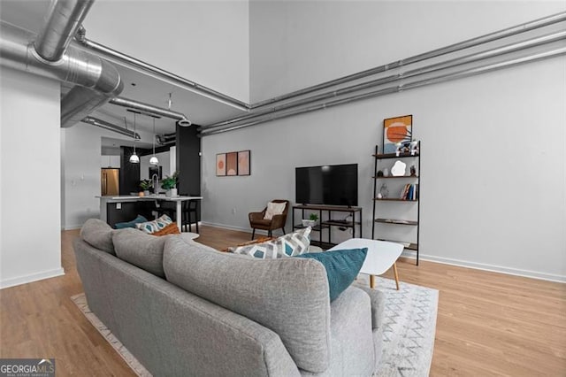 living room with a towering ceiling and wood-type flooring