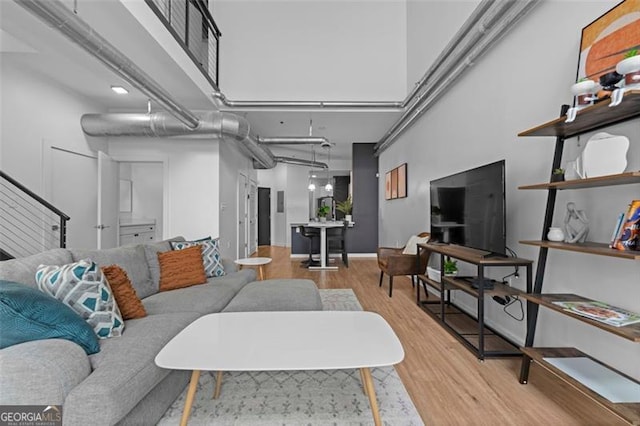 living room with a high ceiling and light wood-type flooring