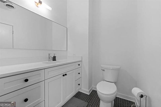 bathroom with vanity, toilet, and tile patterned floors