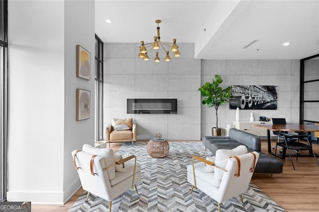 living room featuring light hardwood / wood-style floors, a chandelier, and a tile fireplace