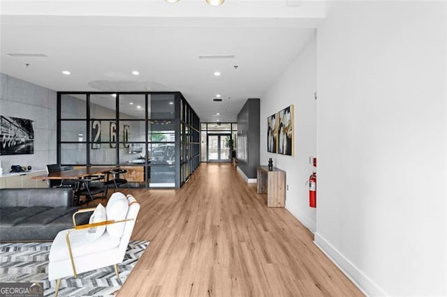 corridor featuring hardwood / wood-style flooring and a wall of windows