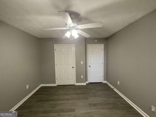 unfurnished bedroom with ceiling fan, a textured ceiling, and dark hardwood / wood-style flooring