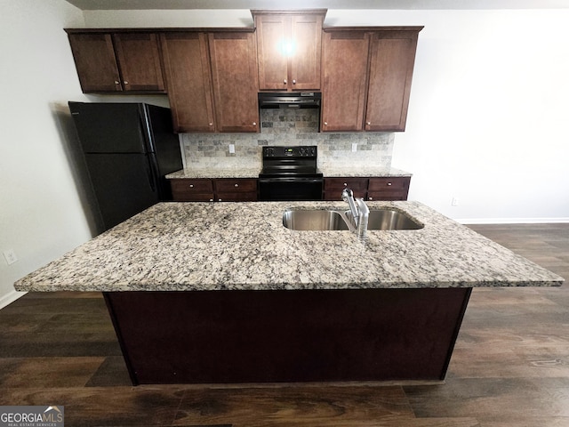 kitchen featuring dark brown cabinets, a kitchen island with sink, black appliances, and sink