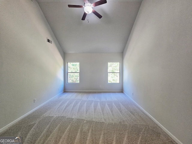 carpeted empty room with ceiling fan and high vaulted ceiling