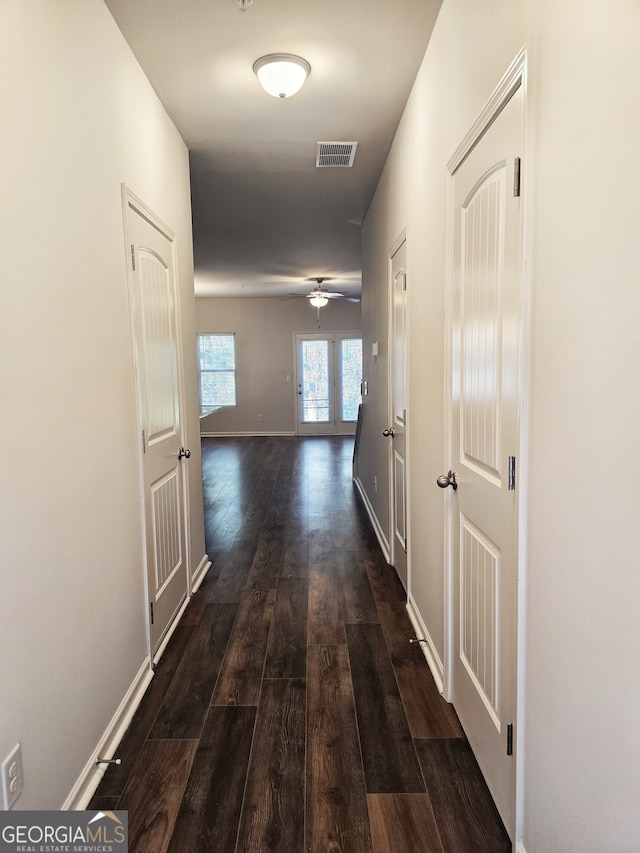 hall with dark wood-type flooring and french doors