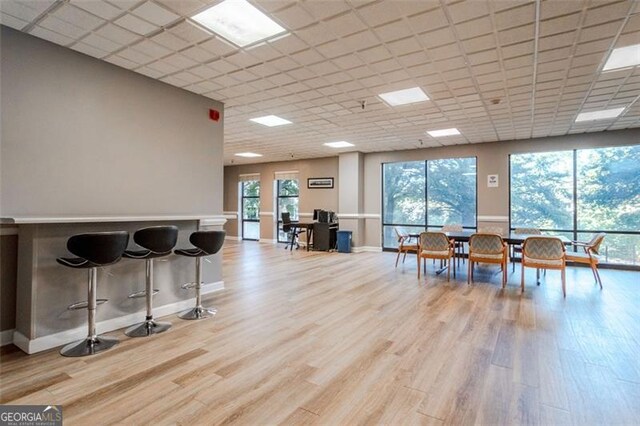 interior space with a drop ceiling and light wood-type flooring