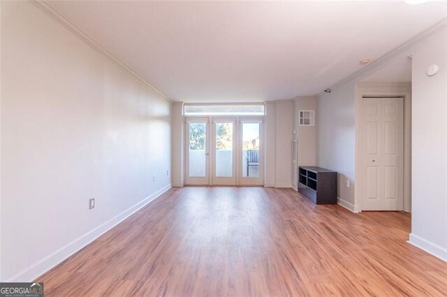 unfurnished living room with french doors, light hardwood / wood-style floors, and ornamental molding