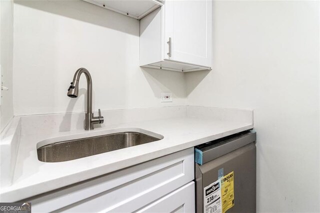 kitchen featuring sink, stainless steel dishwasher, and white cabinets