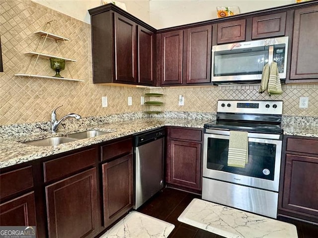 kitchen featuring tasteful backsplash, sink, dark tile patterned floors, stainless steel appliances, and light stone counters