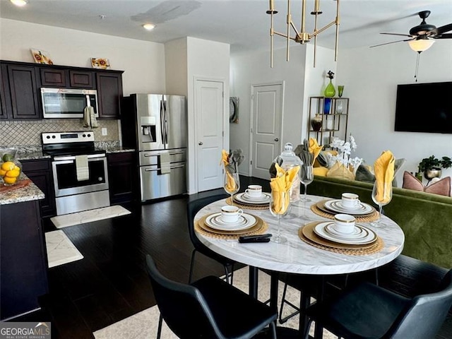 kitchen featuring decorative backsplash, stainless steel appliances, hardwood / wood-style floors, dark brown cabinetry, and light stone counters