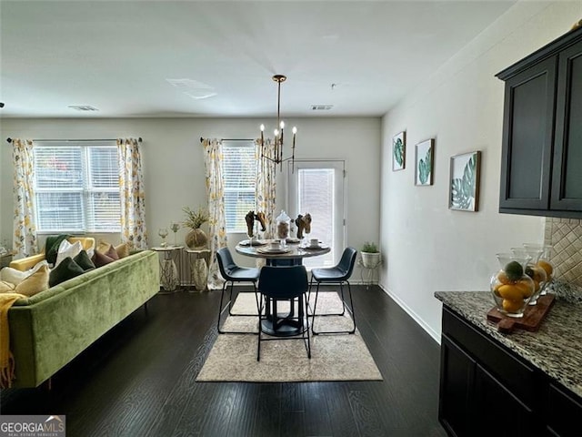 dining area featuring a notable chandelier and dark hardwood / wood-style floors