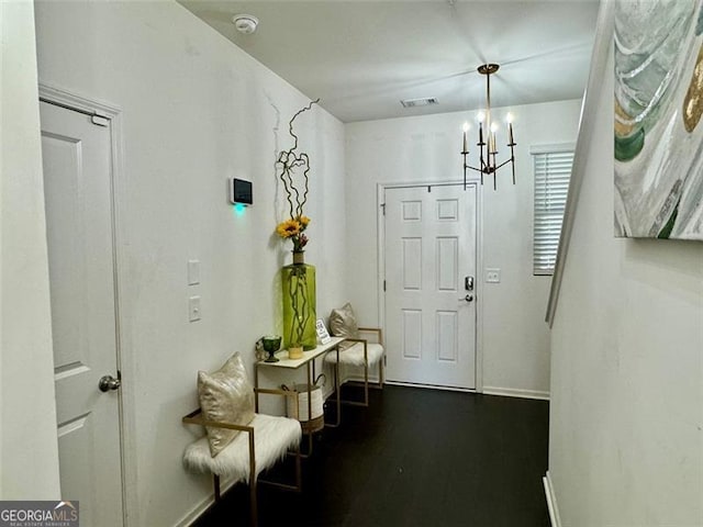 entryway featuring hardwood / wood-style flooring and a chandelier