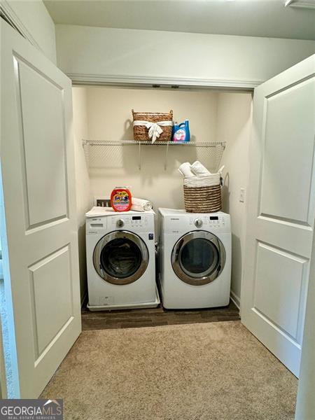 clothes washing area with carpet floors and separate washer and dryer