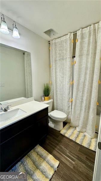 bathroom with vanity, toilet, and hardwood / wood-style floors