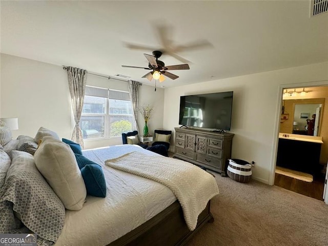 bedroom with carpet floors, ensuite bathroom, and ceiling fan