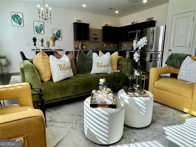 carpeted living room featuring a chandelier