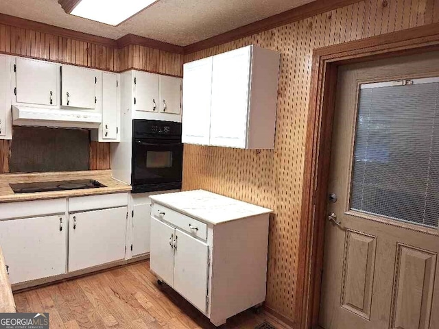 kitchen featuring black appliances, white cabinets, a textured ceiling, and light wood-type flooring