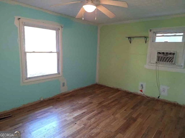 empty room featuring ceiling fan, crown molding, and wood-type flooring