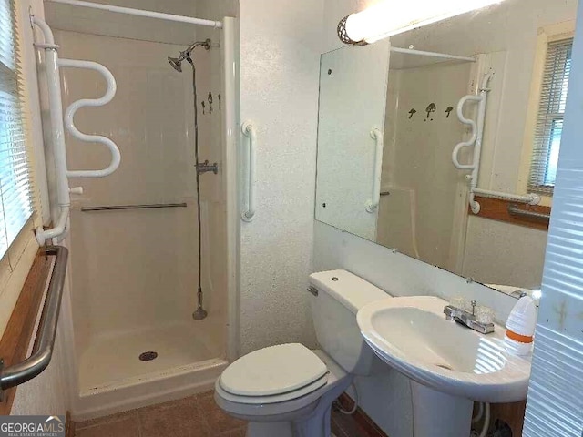 bathroom with tile patterned floors, sink, toilet, and walk in shower