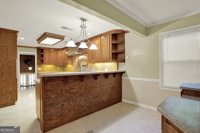 kitchen with crown molding, exhaust hood, kitchen peninsula, and hanging light fixtures