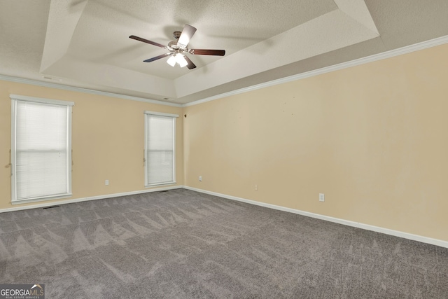 carpeted spare room featuring crown molding, a tray ceiling, a textured ceiling, and ceiling fan