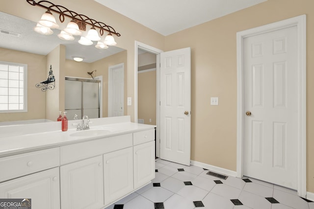 bathroom with vanity, a textured ceiling, and walk in shower